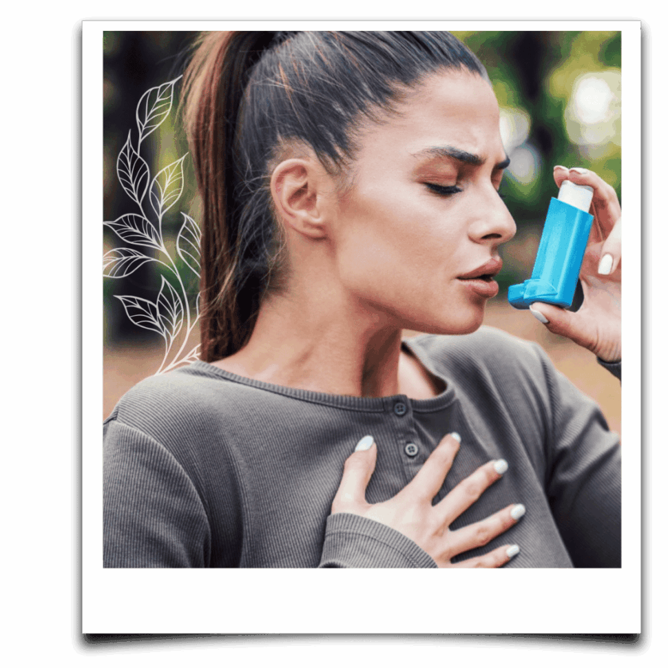 Mladá žena s tmavými vlasy držící modrý inhalátor a rukou na hrudi, v momentu dechové tísně – vizuál symbolizuje problémy s dýcháním.